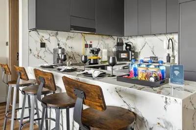 a kitchen with a counter with bar stools at New 1BR with Rooftop Pool and Amazing View in Dubai