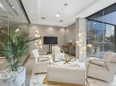 a living room with white chairs and a tv at New 1BR with Rooftop Pool and Amazing View in Dubai
