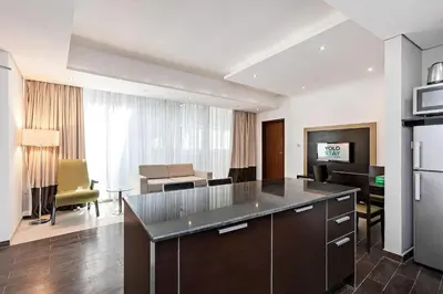 a room with a kitchen and a living room at Comfy 1BR apartment in Sport City in Dubai