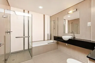 a bathroom with a glass shower and a sink at Comfy 1BR apartment in Sport City in Dubai