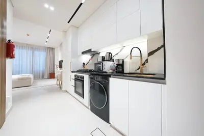 a white kitchen with a washer and dryer at Premium Stay at High-Floor Trillionaire Studio in Dubai