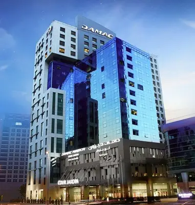 a santara building with a sign on top of it at DAMAC Cour Jardin - Pool & Gym - Free Parking in Dubai