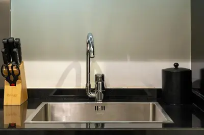a stainless steel sink in a kitchen with scissors at DAMAC Cour Jardin - Pool & Gym - Free Parking in Dubai
