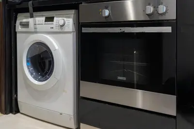 a washer and a washing machine in a kitchen at DAMAC Cour Jardin - Pool & Gym - Free Parking in Dubai