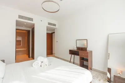 a white bedroom with a bed and a television at Luxury 2-Bedroom Apartment with Stunning City Views By Norbu Holiday Homes in Dubai