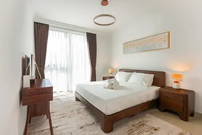 a bedroom with a bed and a dresser and a window at Luxury 2-Bedroom Apartment with Stunning City Views By Norbu Holiday Homes in Dubai