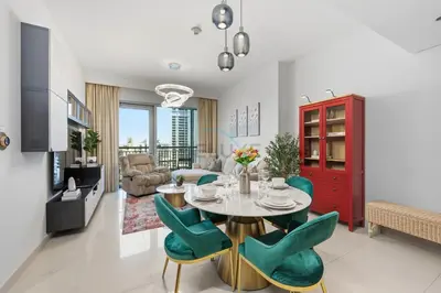a dining room and living room with a table and chairs at Close to Ras Al Khor Wildlife Sanctuary, Just Minutes from Dubai Mall and Burj Khalifa, and Surrounded by Exceptional Amenities - Harbour Views Tower 1, Dubai Creek Harbour by Deluxe Holiday Homes in Dubai