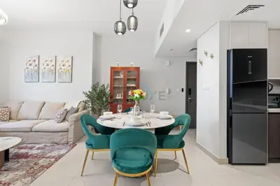 a kitchen and living room with a table and chairs at Close to Ras Al Khor Wildlife Sanctuary, Just Minutes from Dubai Mall and Burj Khalifa, and Surrounded by Exceptional Amenities - Harbour Views Tower 1, Dubai Creek Harbour by Deluxe Holiday Homes in Dubai