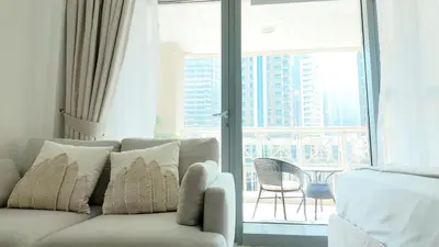 a living room with a couch and a large window at Chic Downtown Studio Few Steps to Burj Khalifa by Simply Comfort in Dubai