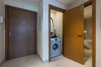 a laundry room with a washing machine and a door at VayK - Great 1BR in Downtown near Burj Khalifa in Dubai