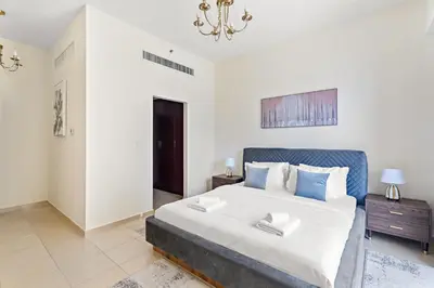 a bedroom with a large bed and a chandelier at VayK - Beautiful 1BR in JBR near the Beach in Dubai