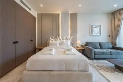 a bedroom with a large white bed and a couch at Studio Escape - Unit 1805 - Near Downtown! in Dubai