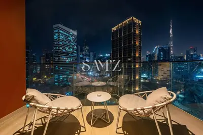 a balcony with chairs and a table and a city skyline at Studio Escape - Unit 1805 - Near Downtown! in Dubai