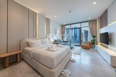 a bedroom with a large bed and a television at Studio Escape - Unit 1805 - Near Downtown! in Dubai