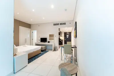 a hotel room with a bed and a dining room at HAVN - Studio in Cour Jardin, Business Bay in Dubai