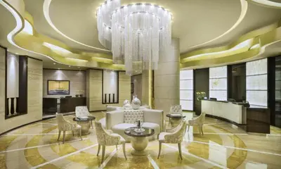 a hotel lobby with a chandelier and a table and chairs at HAVN - Studio in Cour Jardin, Business Bay in Dubai