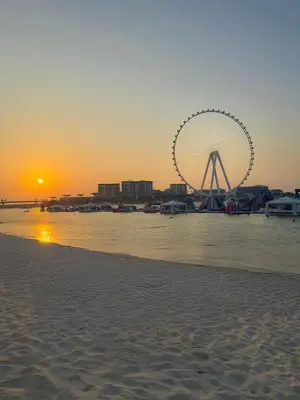 a ferris wheel on the beach at sunset at Khayali Marina Holiday Homes Dubai Marina JBR in Dubai