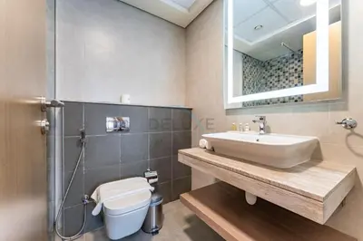 a bathroom with a sink and a toilet and a mirror at Huge Balcony Overlooking Creek Harbour with Glimpses of Burj Khalifa, Just Minutes from Zabeel Stadium, Azizi Aliyah Residence, Al Jaddaf by Deluxe Holiday Homes in Dubai
