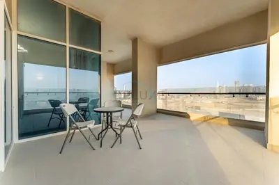 a balcony with a table and chairs and large windows at Huge Balcony Overlooking Creek Harbour with Glimpses of Burj Khalifa, Just Minutes from Zabeel Stadium, Azizi Aliyah Residence, Al Jaddaf by Deluxe Holiday Homes in Dubai