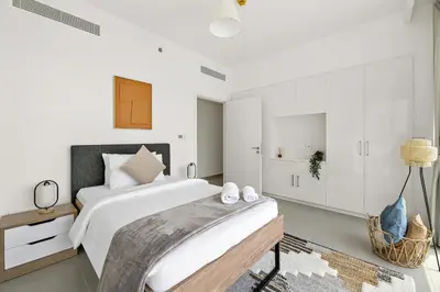 a white bedroom with a large bed and white cabinets at Chic 3BR in Downtown with Burj Khalifa View in Dubai