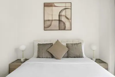 a bedroom with a white bed with two lamps at Chic 3BR in Downtown with Burj Khalifa View in Dubai
