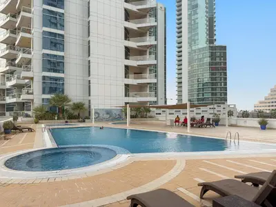 a large swimming pool in front of tall buildings at FIRST CLASS 2BR Breathtaking Marina Views in Dubai