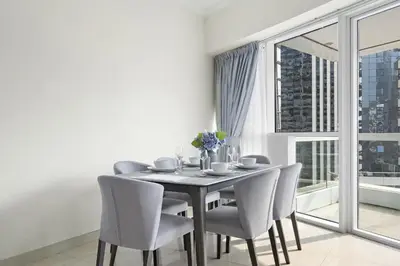 a dining room with a table and chairs and a window at VayK - Spacious 2BR in JLT with Marina Views in Dubai