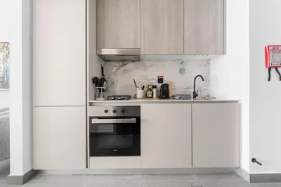 a kitchen with white cabinets and an oven at VayK - Modern Studio with Great Amenities in Dubai