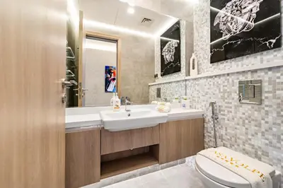a bathroom with a sink and a toilet and a mirror at VayK - Ultra-Luxury 3BR Marina Retreat with Stunning View in Dubai