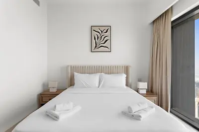 a bedroom with a large white bed and a window at VayK - Stylish 1BR in Prime Downtown Location in Dubai