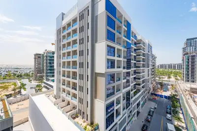 an aerial view of a tall white building at VayK - Brand New 1BR in Dubai Hills in Dubai