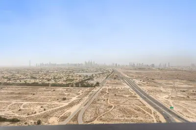 an aerial view of a desert with a city at VayK - Stylish 2BR in JVC with Private Pool in Dubai