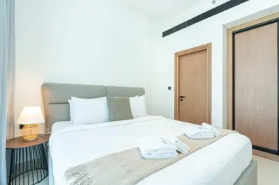 a bedroom with a white bed with towels on it at PVH - Cozy 1BR with City View - Binghatti House in Dubai