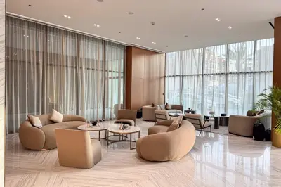 a lobby with chairs and tables and large windows at PVH - Cozy 1BR with City View - Binghatti House in Dubai