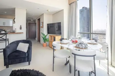 a kitchen and living room with a table and chairs at Frank Porter - Hilliana Tower in Dubai