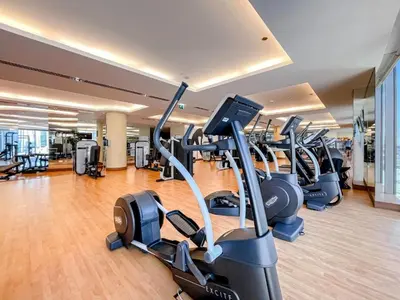 a gym with rows of treadmills and elliptical machines at 1 Bedroom Apartment at Marina with Stunning View in Dubai