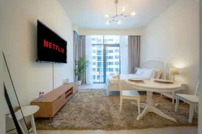 a living room with a white table and a white couch at AWS Holiday Homes - Comfy Cozy Studio in Dubai