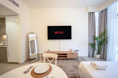 a hotel room with a television on the wall at AWS Holiday Homes - Comfy Cozy Studio in Dubai