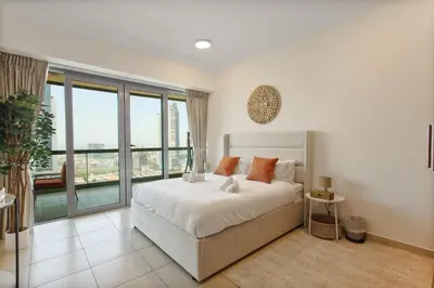 a bedroom with a bed and a large window at Bright 2BR with Burj, Sea & City Views - Walk to Mall in Dubai