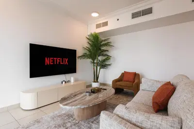 a living room with a couch and a tv at Bright 2BR with Burj, Sea & City Views - Walk to Mall in Dubai