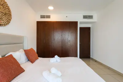 a bedroom with a white bed with two pillows at Bright 2BR with Burj, Sea & City Views - Walk to Mall in Dubai