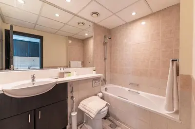 a bathroom with a sink and a toilet and a tub at HAVN - Studio in Alka, The Greens in Dubai