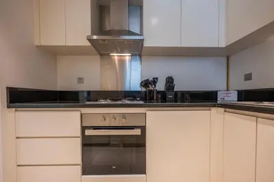 a kitchen with white cabinets and a stove top oven at Chic 1 Bedroom in Business Bay in Dubai