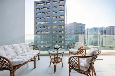 a living room with chairs and a table and a large window at Chic 1 Bedroom in Business Bay in Dubai