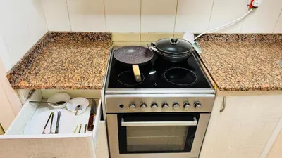 a kitchen with a stove with a pot on it at Beautiful 1 Bedroom Apartment close to metro in Dubai