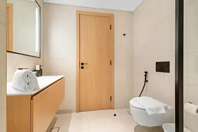a white bathroom with a toilet and a sink at FIRST CLASS Studio Marquise Bliss in Dubai