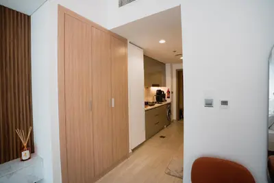 a hallway with a large wooden door in a kitchen at Azizi Riviera Modern Studio Near Downtown in Dubai