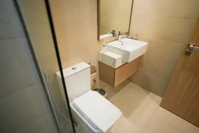 a bathroom with a toilet and a sink and a mirror at Azizi Riviera Modern Studio Near Downtown in Dubai