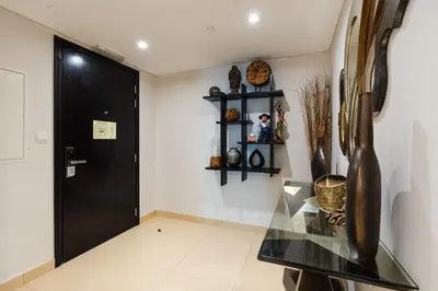 a hallway with a glass table and a black door at Comfortable - Vibrant - Convenient in Dubai