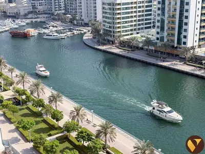 two boats in a river in a city with buildings at Vogue Marina Dorra Bay near JBR Beach and Ain Dubai, Two Bedroom apartment with Balcony, Canal and Skyline View, Access to all Amenities in Dubai
